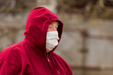 Portrait of an elderly European man with a short haircut in a protective safe medical mask, close-up.の写真素材