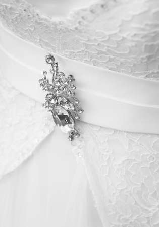 Decoration brooch with diamonds on the wedding white dress of the bride, close-up.の写真素材