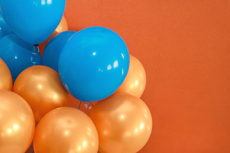 Blue and orange holiday balloons decor the interior on a brown background, copy space or place for...