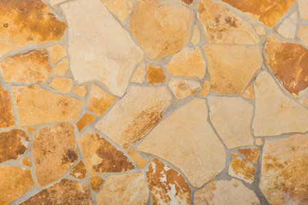 Light yellow and brown stone tile pattern wall surface texture background.
