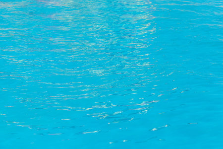 Blue clear pool water with abstract pattern of reflection and wave surface background.