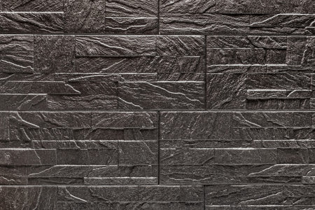 Black decorative stone tile texture with abstract patterns background.