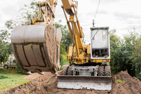 Bucket and hydraulic piston excavator or bulldozer close-up in industrial zone.
