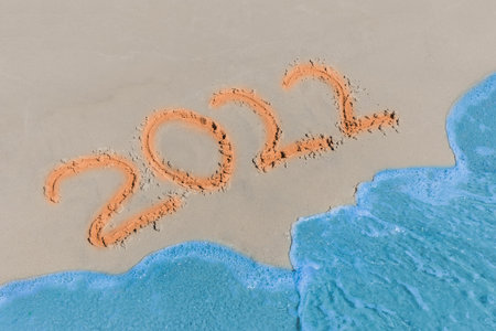 2022 sign and symbol word written text on the beach sand.