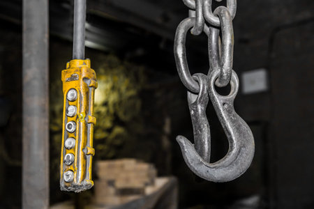 Remote control old control panel lifting industrial mechanism iron hook in the workshop of the...