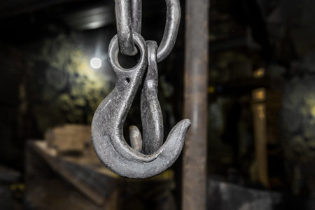Lifting mechanism iron chain with hook equipment heavy crane at factory.