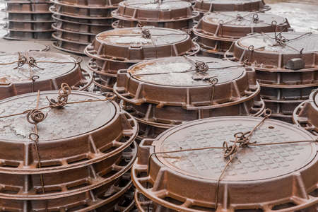 Old rusty manholes are packed and stored outdoors.の写真素材