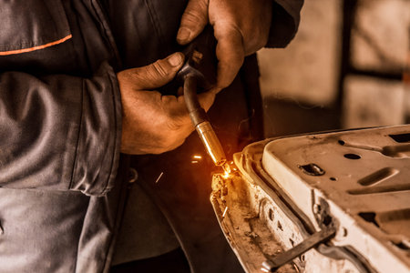 Close up of the process of work on metal, welding of the welder's hand in industry.