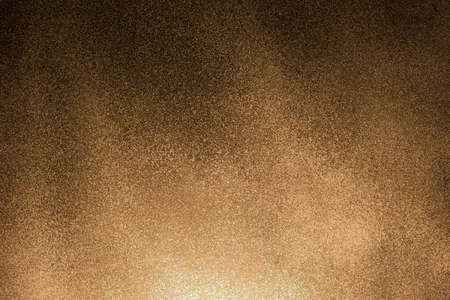 Dark detailed wall surface with an orange tinge of light old texture background.の写真素材