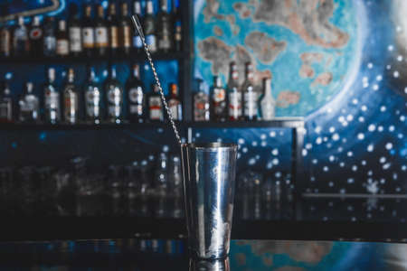 Metal tool for cooking and stirring alcoholic cocktails shaker with bar spoon on the bar counter.の写真素材