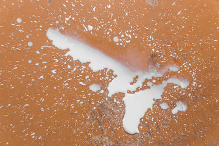 Spilled milk liquid mess and puddle splashes on the floor.の写真素材
