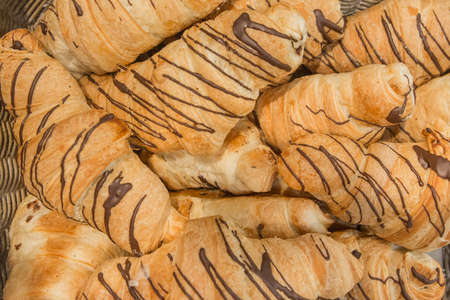Fresh croissants with chocolate filling background baking bakery counter.の写真素材
