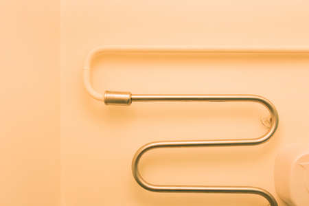 Metal warm towel dryer in the bathroom on the wall hot pipe at home.の写真素材