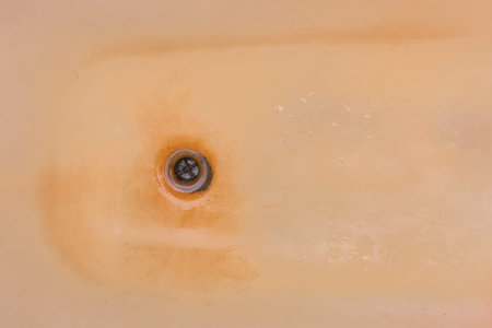Old dirty bath with rust and a hole for drain fluzing impure water into sewer.の写真素材