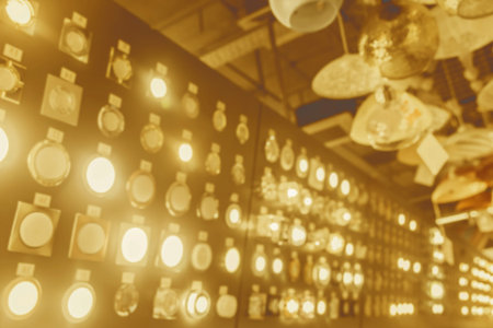 Blurry warm color unsharp abstract shiny background of glowing light bulbs and lamps in the store.
