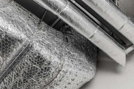 Ventilation air conditioning system in thermal insulation material duct pipe hvac pipeline on the ceiling of an industrial plant.の写真素材