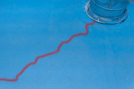 Crack on the old blue broken plaster wall of damage near the ventilation pipe of the industrial plant.の写真素材