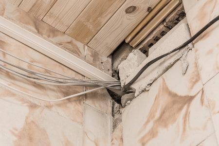 Old cable cord wiring insulation system on the wall near the ceiling.の写真素材