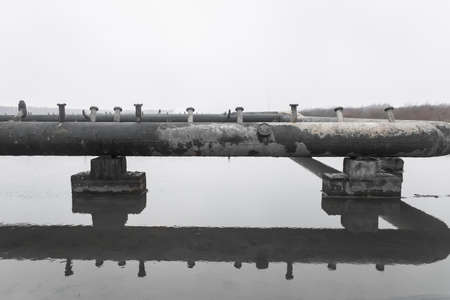 Old steel rusty abandoned pipes of the water cooling pipeline system of the combined heat and power industrial plant.の写真素材