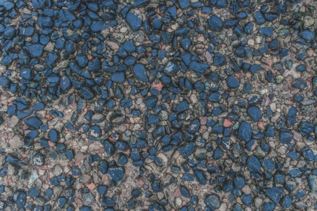 Pebbles dark blue river stone natural background shore surface rough rock.