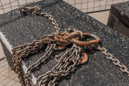 Iron hoist tool hook load heavy lifting weight sling mechanism chain fixed on concrete structure.の写真素材