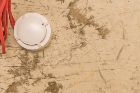 Old fire alarm on ceiling smoke detector safety and home protection from dangerous situations with fire, close-up.の写真素材