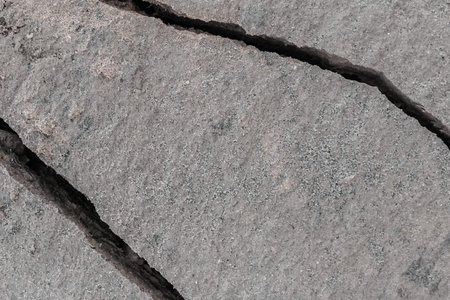 Large crack after earthquake on the soil surface of the earth damaged ground background climate...