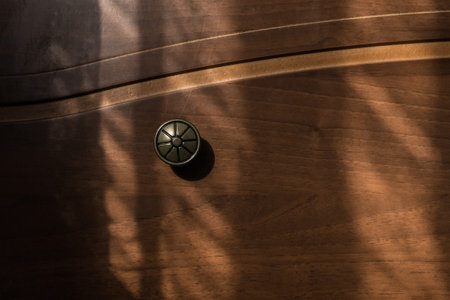 Metal vintage handle brown antique dresser with sun light and shadow silhouette object design of furniture and interior of the house room, close-up.の写真素材