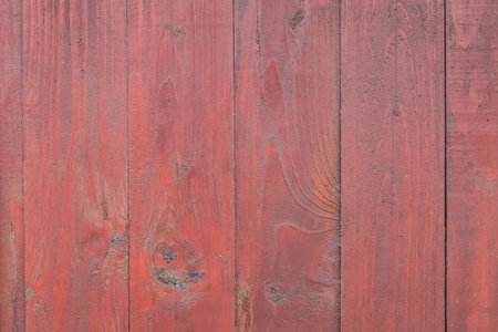 Old wooden worn fence boards weathered texture in peeling red paint dirty obsolete background.の写真素材