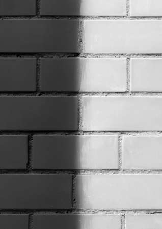 Brick wall paint two colors dark black and white or light abstract urban background design art texture.の写真素材