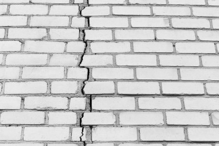 Old white cracked brick texture wall damaged background broken.
