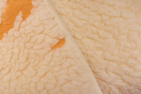 Yellow sheep material wool fur soft structure fleece fabric background texture warm natural nature...