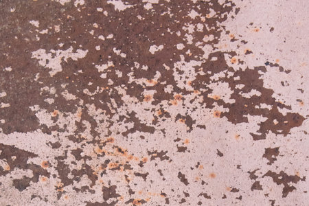 Light pink paint peeling off from the surface of the old metallic texture grunge steel background...