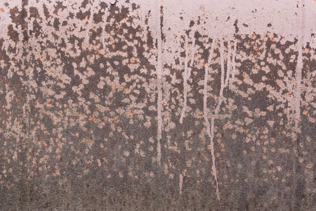 Light pink paint peeling off from the surface of the old metallic texture grunge steel background...