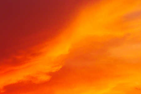 Red-orange sunset bright clouds sky color nature background.の写真素材