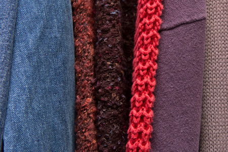 Set of different colored fabric clothes vintage textile background, close-up.
