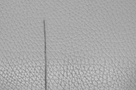 Cut on leather gray material torn old vintage textile damaged.