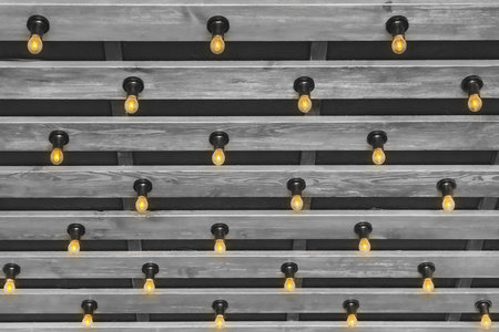 Modern wooden interior design style with gray plank ceiling and light bulbs background.の写真素材