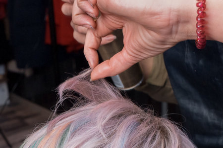Close-up stylish fashion hairstyle color creative coloring bob and professional worker's hand styling hair.の写真素材