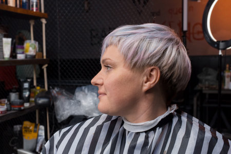 Portrait in profile of an adult sweet and pleasant woman of a barbershop client with a stylish, fashionable bob hairstyle creative color hair coloring in the salon.の写真素材