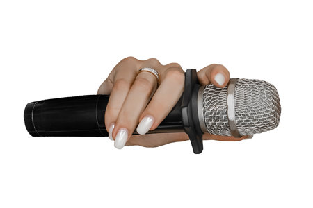 Hand of a young girl with a manicure and a ring holding a microphone on a white background, isolated.の写真素材