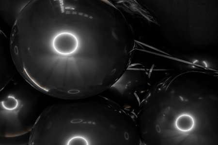 Black stylish helium balloons for a modern holiday festival close up.