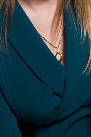 Women's blue blazer fashion and style of clothing with neck pendant decoration.