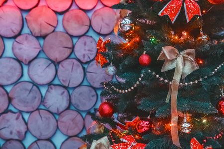 Christmas tree decorated with bows, balloons and toys, bright beautiful holiday atmosphere on a wooden background of the interior.の写真素材