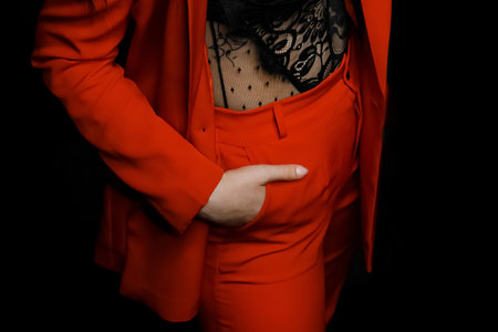 Girl's hand in the pocket of red trousers, business look, clothing style, close-up.の写真素材