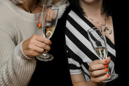 The hands of an adult womans in close-up holds a glass of chilled sparkling champagne, close up.の写真素材