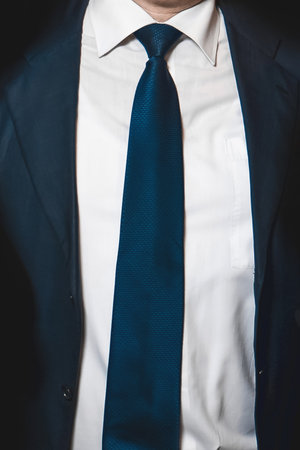 Men's business style clothing fashion white shirt and blue tie and suit jacket close-up soft focus.の写真素材