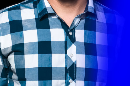 Men's business style fashion shirt with abstract pattern big blue and white check in neon light close-up.の写真素材