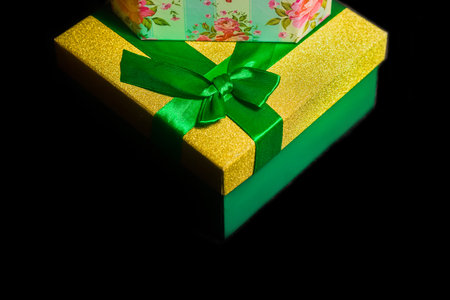 New Year's gifts, a beautiful gift box yellow and green with a ribbon on a black background.の写真素材