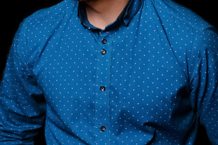 Men's business look fashion style blue shirt with abstract pattern in small white polka dots on dark background, close up.の写真素材
